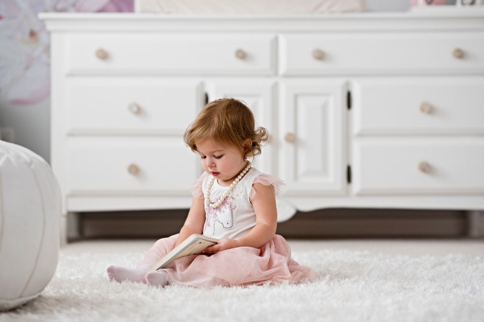 white fluffy area rug in bathroom with little girl reading book, design by cynthia soda